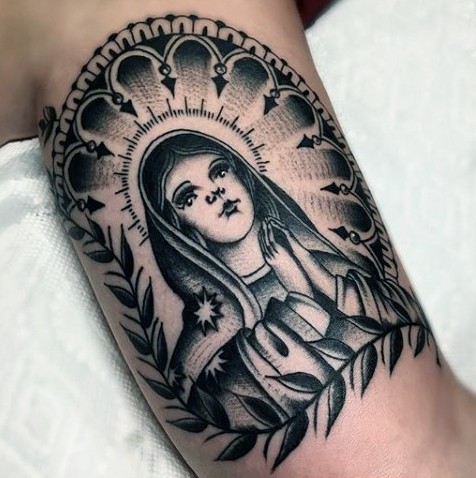 Blackwork style colored biceps tattoo of saint woman
