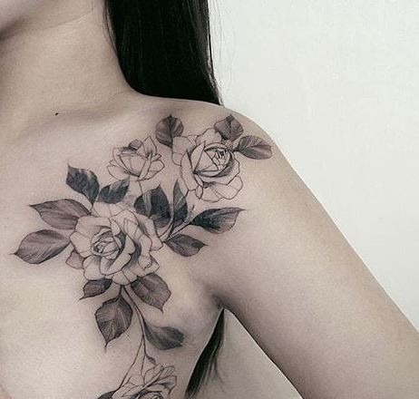 Blackwork style colored collarbone tattoo of roses