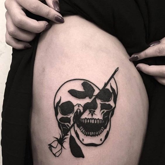 Blackwork style cool looking thigh tattoo of human skull with black rose