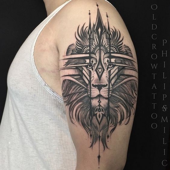Blackwork style cool looking upper arm tattoo of lion head with cool ornaments
