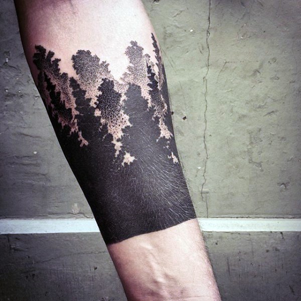 Blackwork style forearm tattoo of dark forest