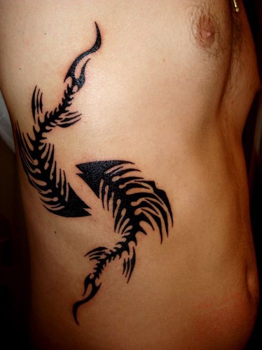 Blackwork style interesting looking side tattoo of fish skeletons