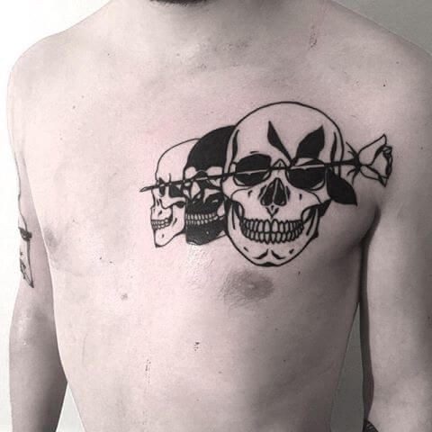 Blackwork style interesting looking three skull on chest with rose