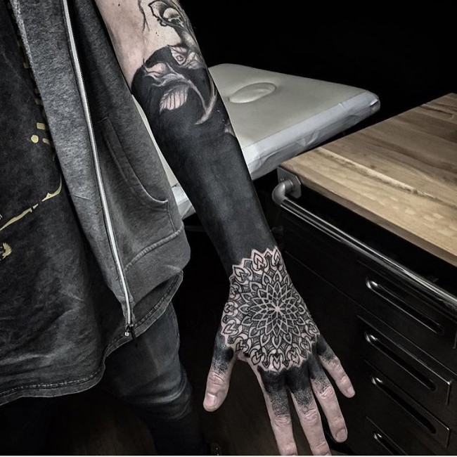 Blackwork style large black ink forearm tattoo stylized with flower