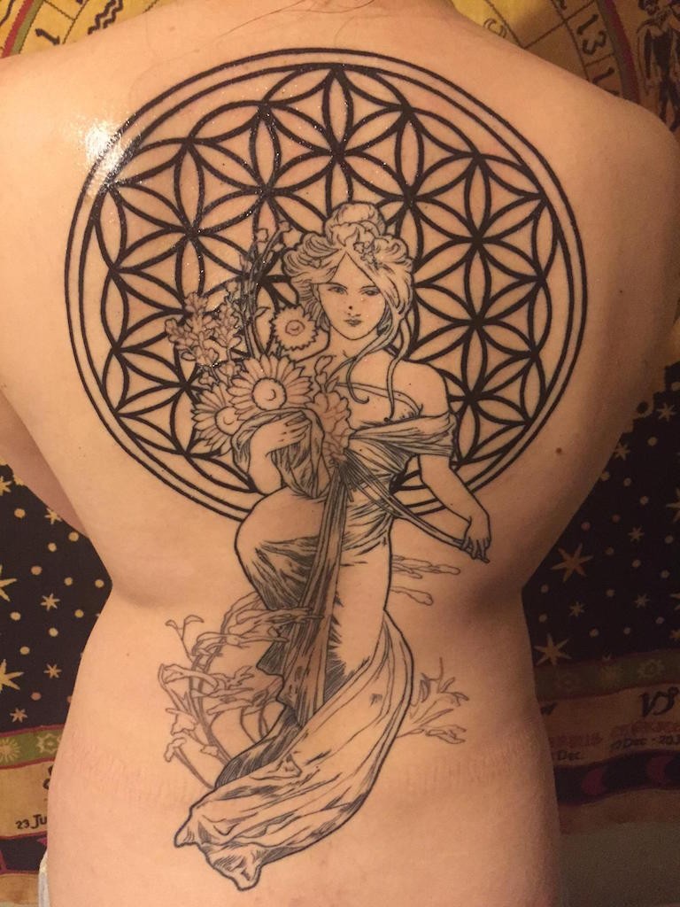 Blackwork style large whole back tattoo of woman with flowers