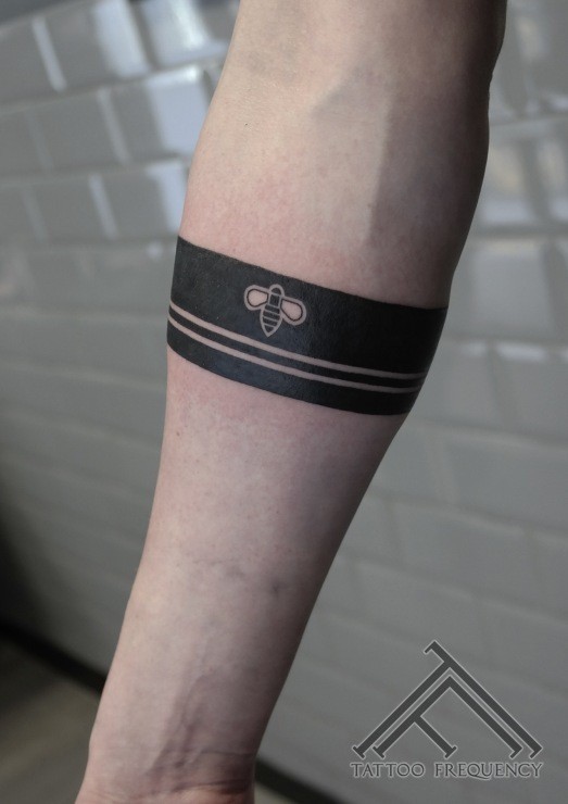 Blackwork style simple arm tattoo of lines stylized with small bee
