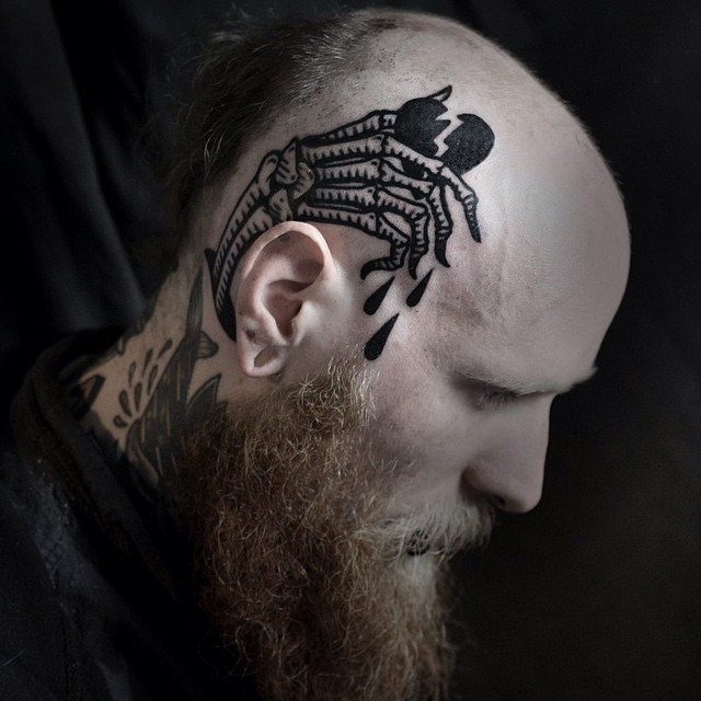 Blackwork style simple looking head tattoo of skeleton hand with broken heart