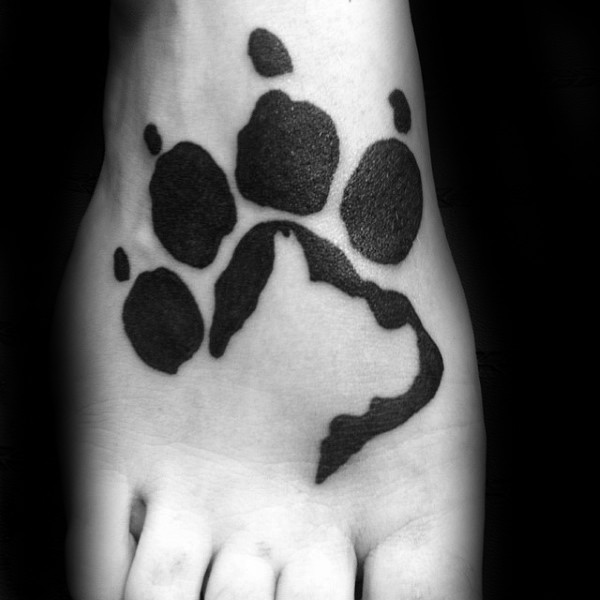 Blackwork style simple looking leg tattoo of paw print