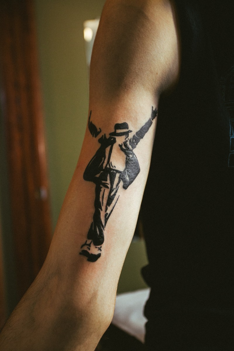 Blackwork style small arm tattoo of dancing Jackson