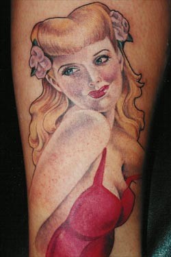 Tatuaje en la pierna, chica rubia linda en vestido rojo