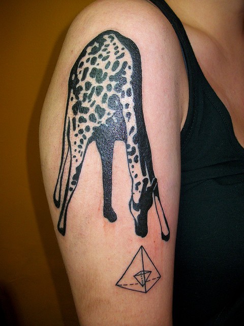Tatuaje en el brazo,  jirafa bonita de colores negro y blanco