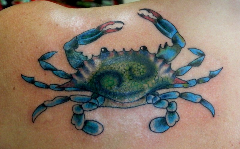 Tatuaje en el hombro, cangrejo  con signo en la espalda