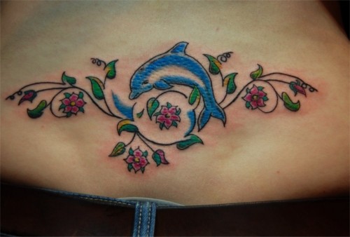 Blue dolphin and floral patterns tattoo on lower back