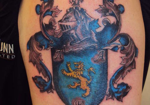 Blue family crest tattoo on shoulder
