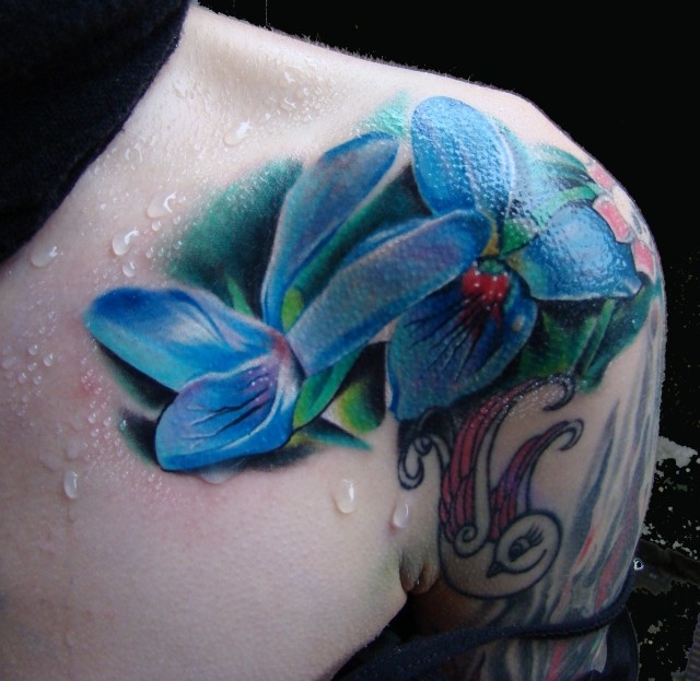 Tatuaje en el hombro, flores azules volumétricos