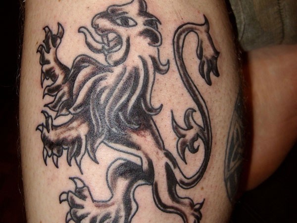 Tatuaje en la pierna, león bohemio negro
