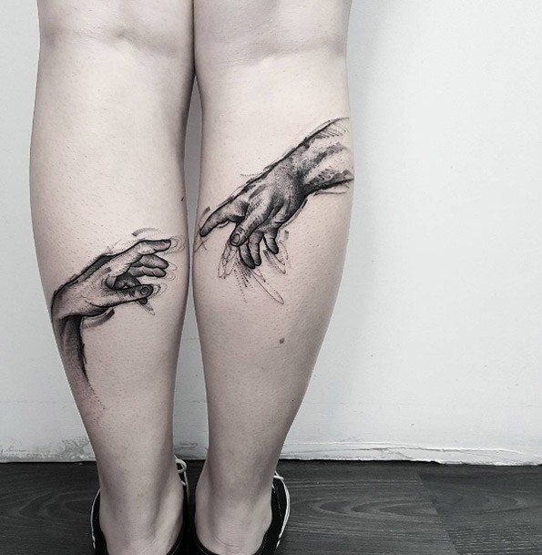 Breathtaking black ink on legs tattoo of human hands