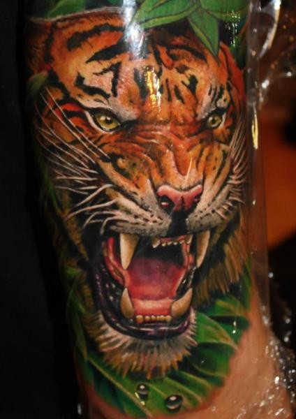 Breathtaking realism style colored arm tattoo of roaring tiger face