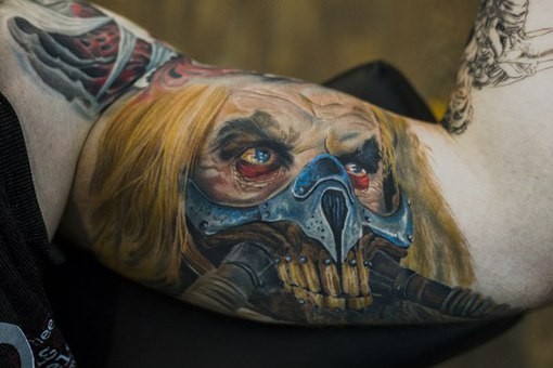 Breathtaking very detailed biceps tattoo of Mad Max villain