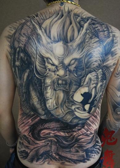 Breathtaking very detailed colored Asian evil dragon tattoo on whole back with Great Wall