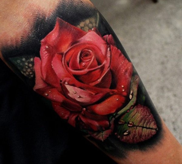 Breathtaking very detailed natural colored rose with water drops tattoo on arm
