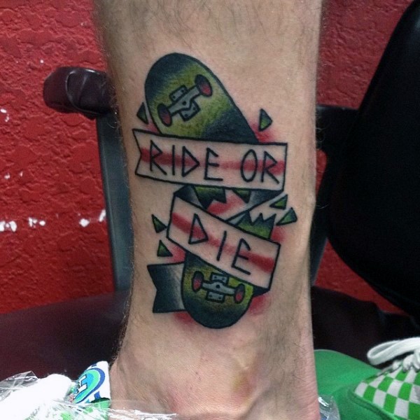 Broken skateboard colored old shool style tattoo on ankle with banner lettering