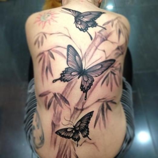 Tatuaggio grande sulla schiena le farfalle & il bambù