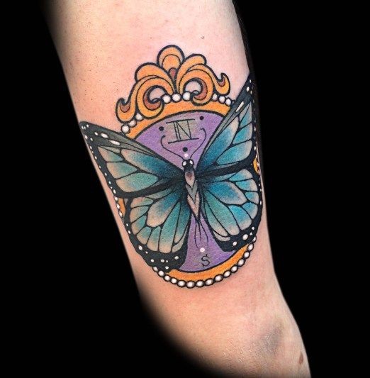 Tatuaggio colorato sul braccio la farfalla sull&quotorologio