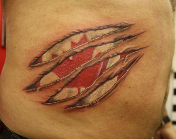 Canadian flag under skin rip tattoo