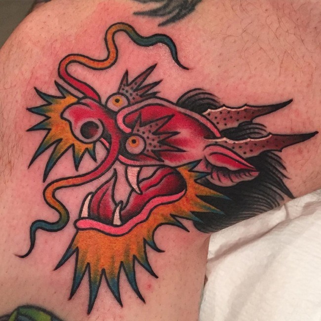 Tatuaje en la pierna, cabeza de dragón loco abigarrado