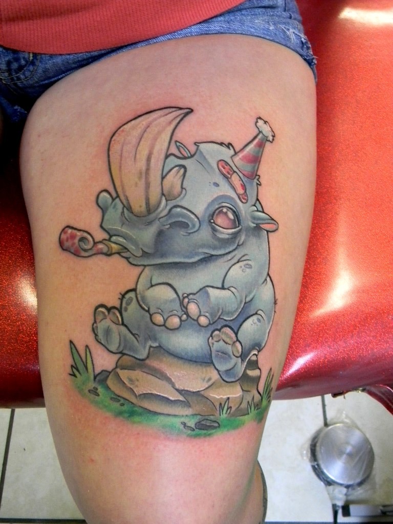 Tatuaje en la pierna,
rinoceronte de dibujos animados en la fiesta