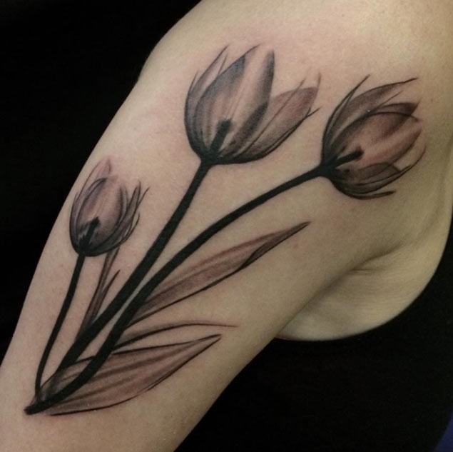 Cartoon like big upper arm tattoo of three tulips