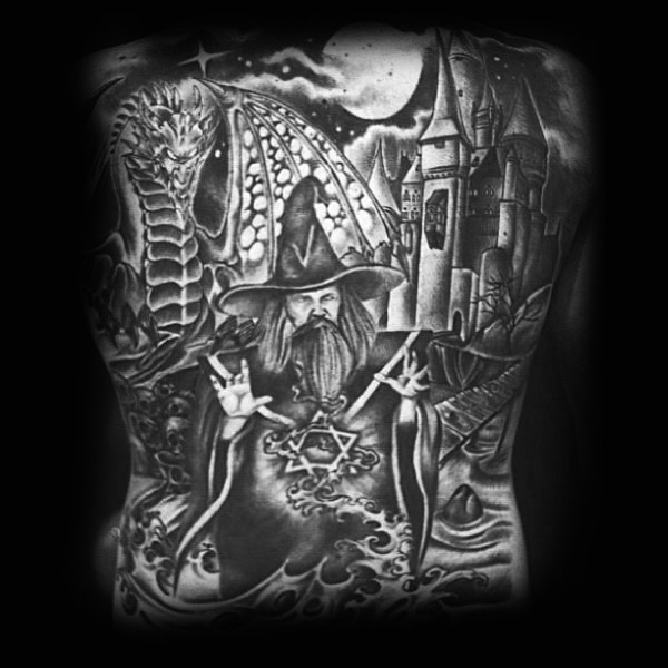 Cartoon like black and white fantasy world with wizard and dragon tattoo on whole back