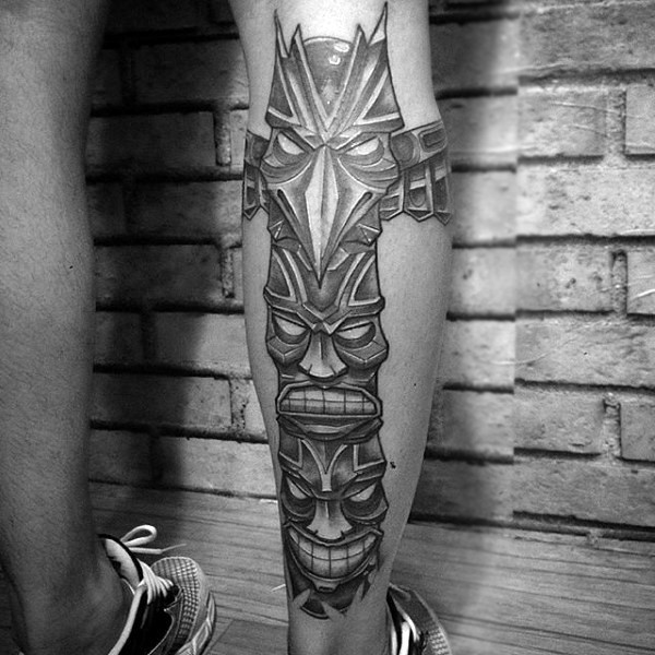 Cartoon like black and white tribal statue tattoo on leg