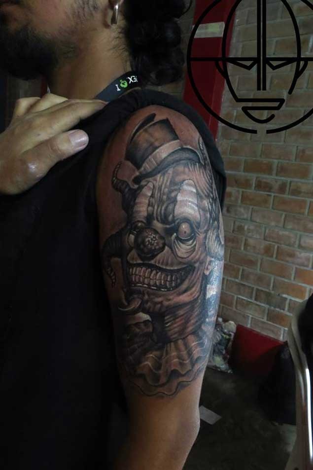 Cartoon like colored and detailed shoulder tattoo of evil monster clown