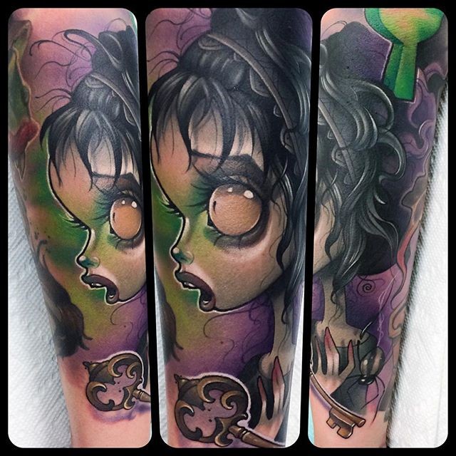 Cartoon like colored evil witch tattoo on forearm with antic key