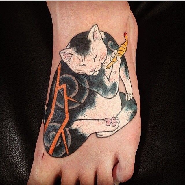 Cartoon like colored foot tattoo of Manmon cat with smoking pipe
