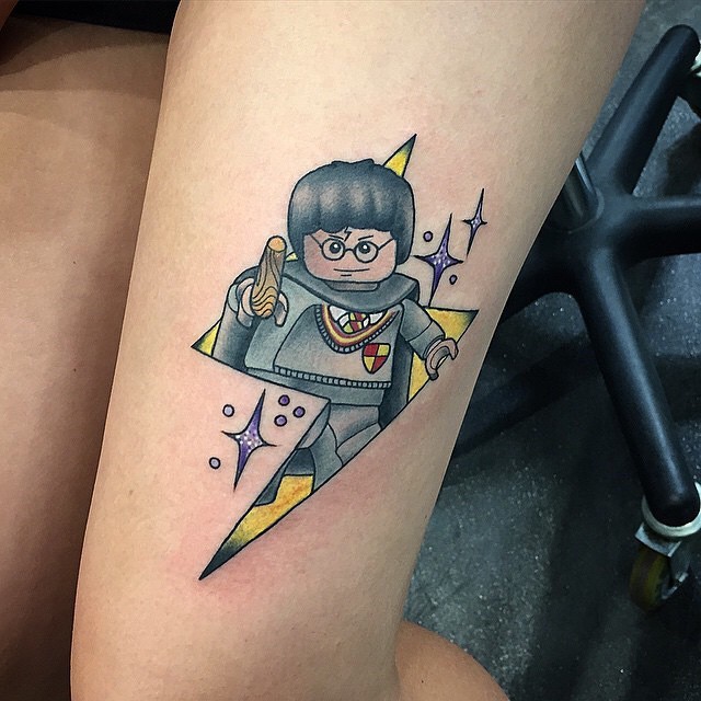 Cartoon like colored funny on thigh tattoo of Lego Harry Potter
