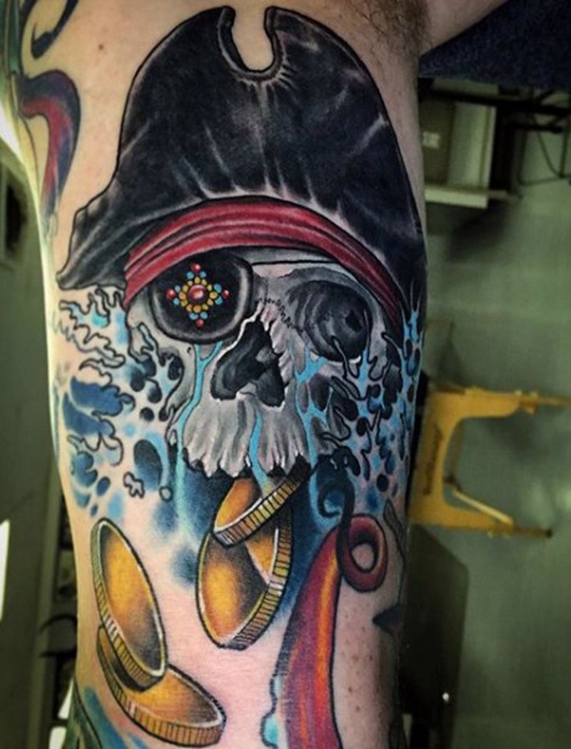 Tatuaje en el brazo,
cráneo de pirata con monedas de oro
