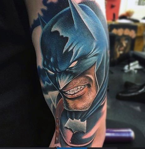 Cartoon like colored shoulder tattoo of angry Batman
