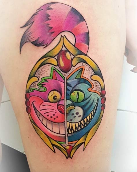 Cartoon like colored thigh tattoo of Cheshire cat portrait