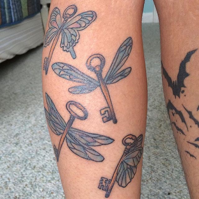Tatuaje en la pierna, montón de llaves antiguas  fantásticas con alas de libélulas