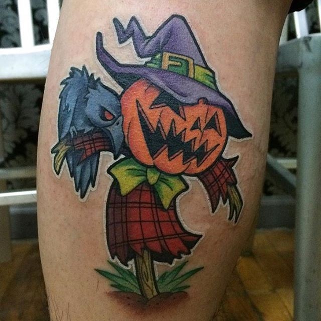 Cartoon like funny colored scarecrow tattoo on leg