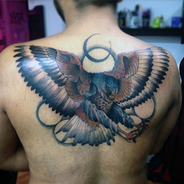 Cartoon like painted and colored detailed flying eagle tattoo on upper back