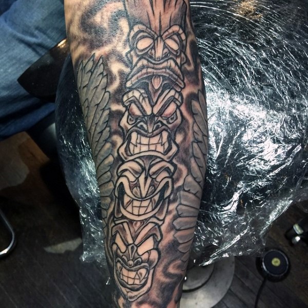 Cartoon like painted colored tribal totem tattoo on arm