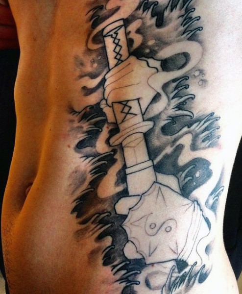 Tatuaje negro blanco en el costado,  espada de samurái en las manos