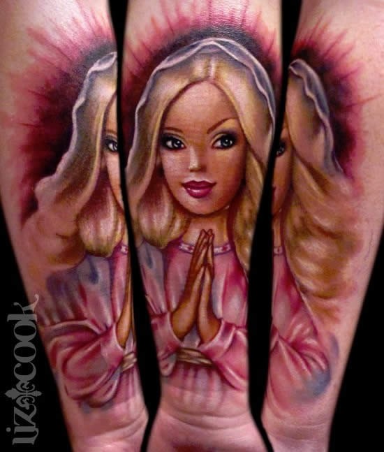 Cartoon style colored forearm tattoo of praying doll