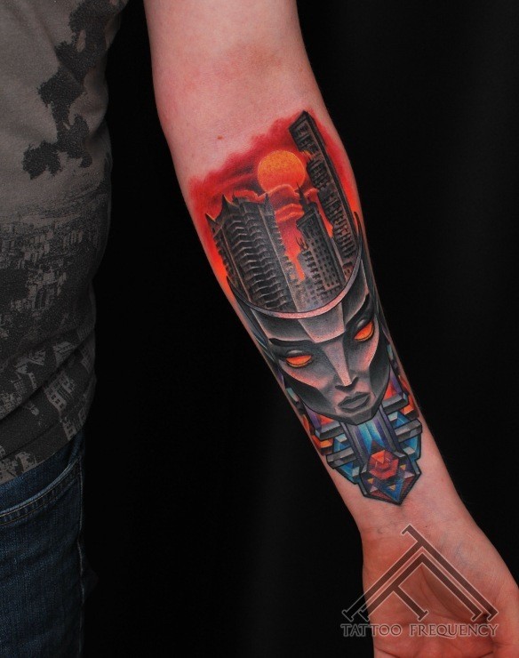 Cartoon style colored forearm tattoo of alien mask with city