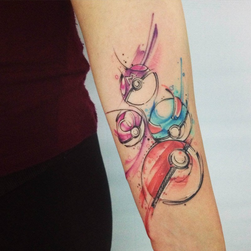 Cartoon style colored Pokemon balls tattoo on forearm