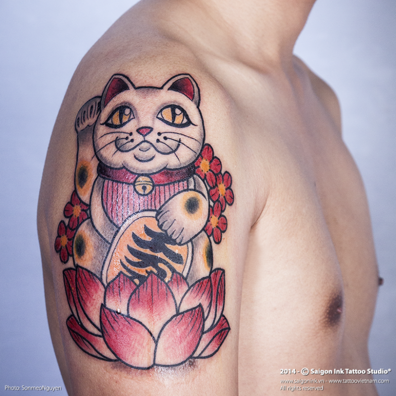 Cartoon style colored shoulder tattoo of typical maneki neko japanese lucky cat with lotus flower and symbols